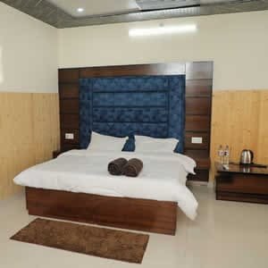 Well-appointed deluxe bedroom at Hotel Sakshi Uttarkashi, a top choice for a budget hotel in Uttarkashi