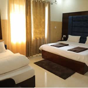Spacious triple bed family room at Hotel Sakshi Uttarkashi, offering premium comfort as a luxury hotel in Uttarkashi