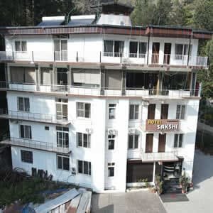 Front view of Hotel Sakshi Uttarkashi, best hotel in Uttarkashi Uttarakhand with modern architecture and mountain views.