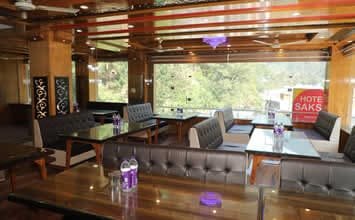 Comfortable in-house restaurant at Hotel Sakshi Uttarkashi featuring comfortable booth seating and a clean dining environment